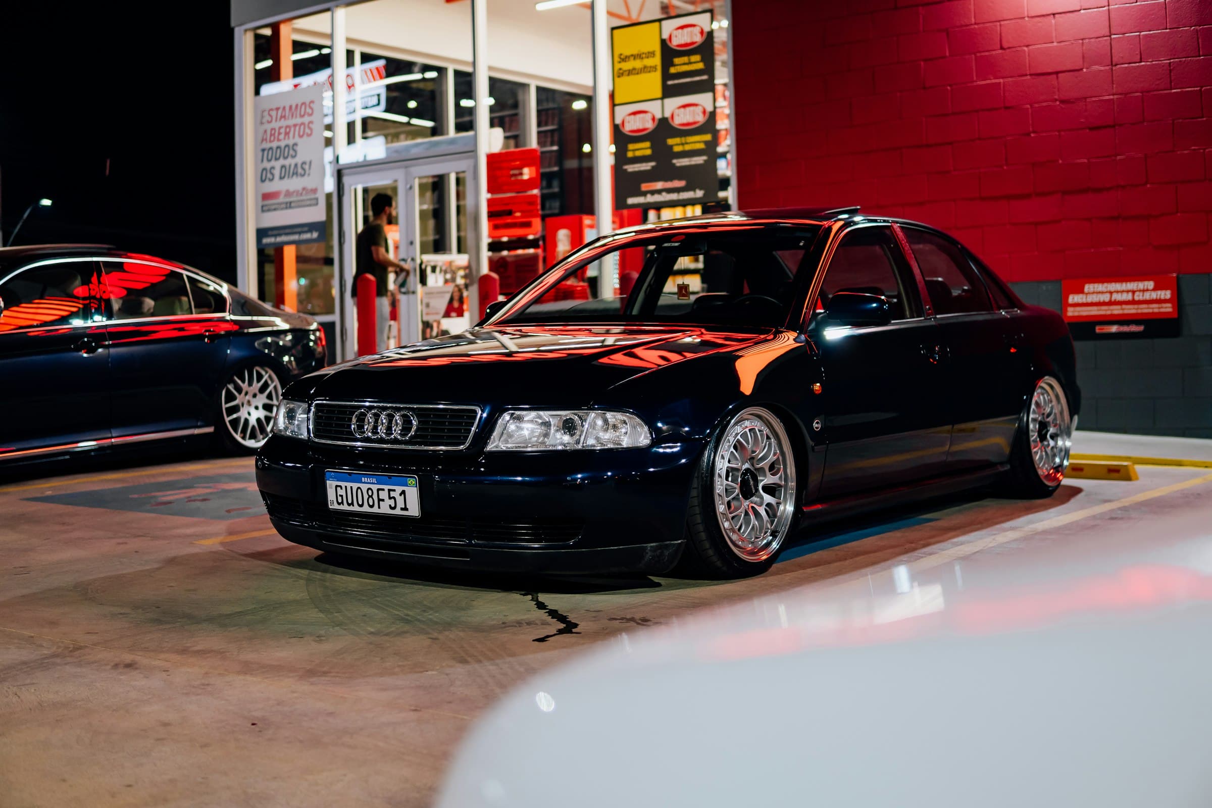 A dark sedan parked outside a building at night